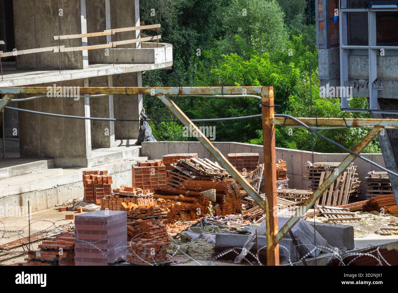 Tonziegel auf einer Baustelle, Holzpaletten und Betonwände. Teil des Rahmens. Stockfoto