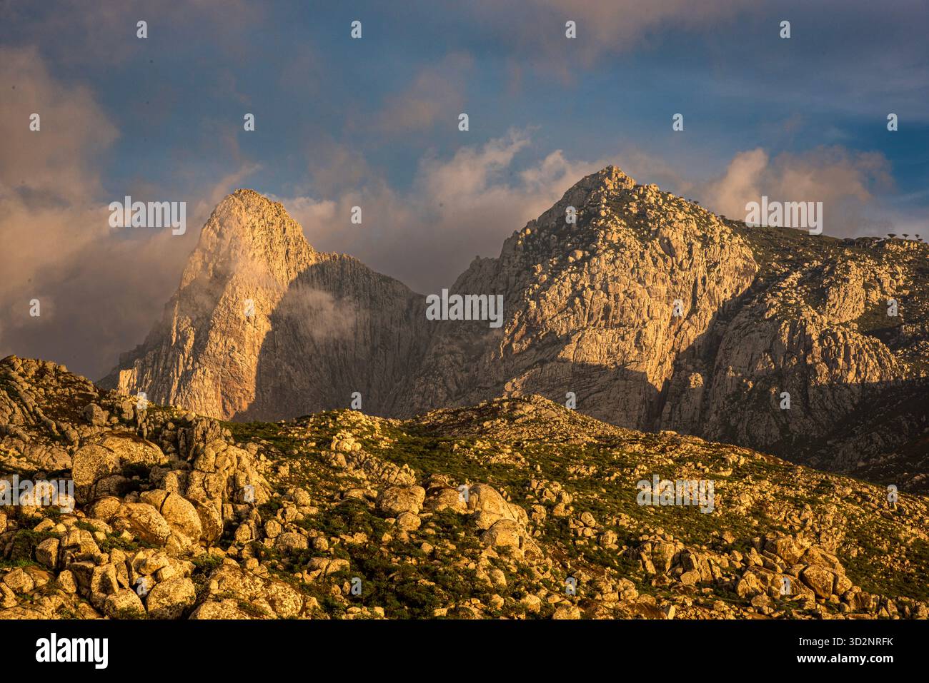 Atemberaubende Landschaft der Hajhir Berge in Socotra, Jemen bei einem dramatischen Sonnenuntergang. Wolken schweben über dem zerklüfteten Gelände. Stockfoto
