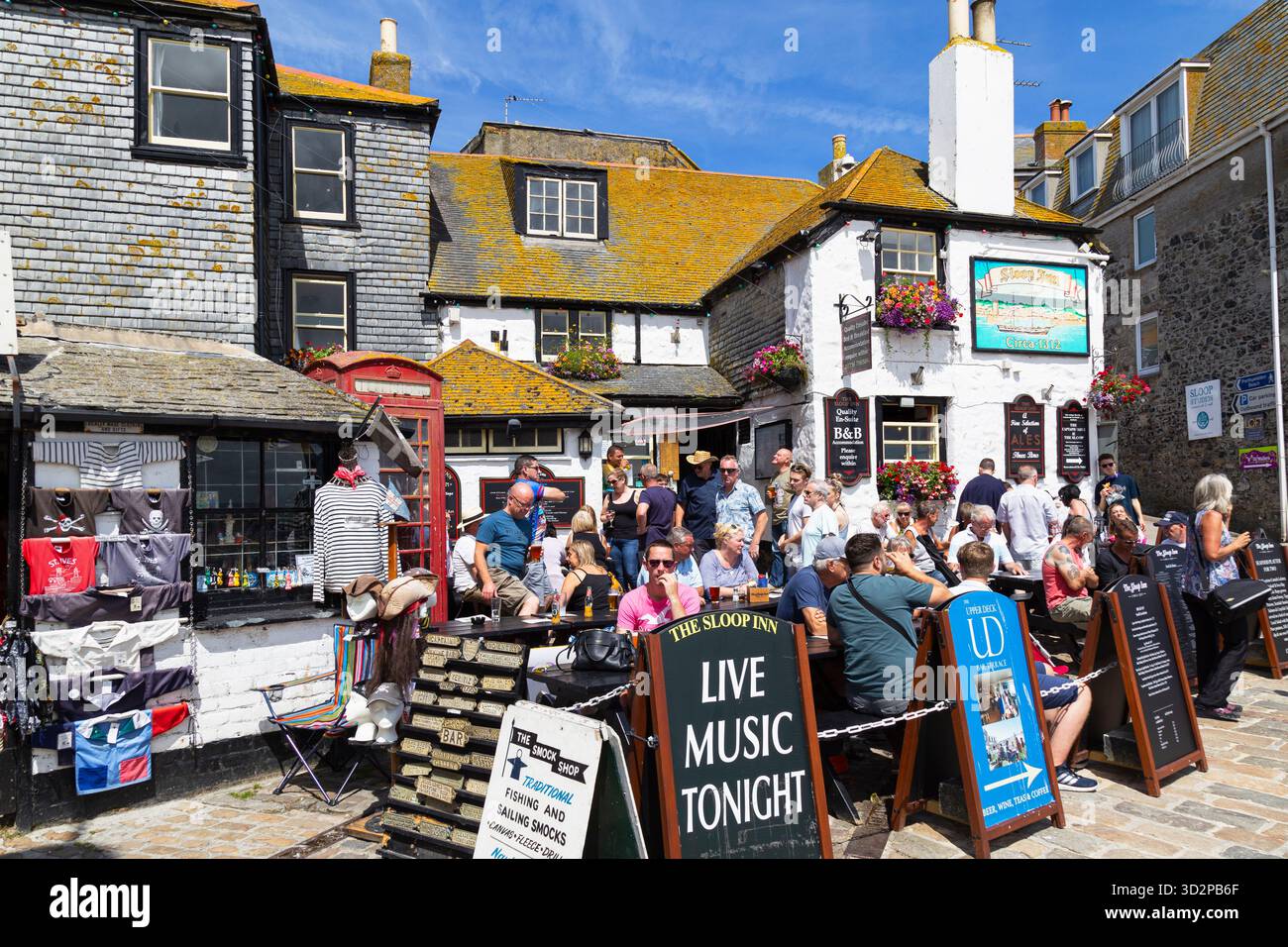 Viele Touristen genießen das Pub an der Seepromenade des Fischerdorfs St. Ives an der Küste von Nord-Cornwall, England. Stockfoto