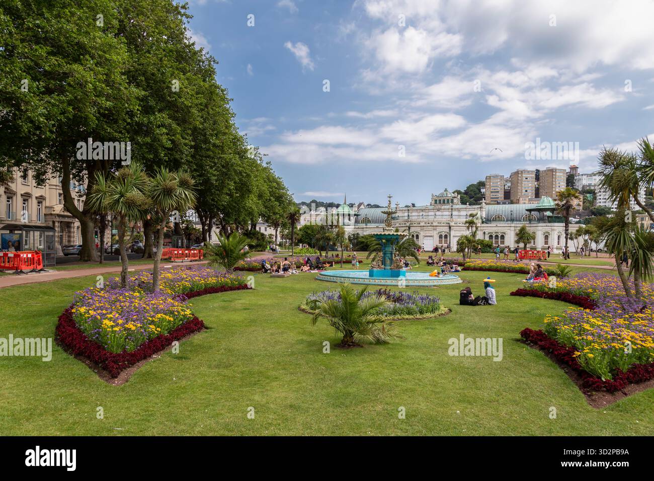 Die Menschen genießen das Wasser aus dem Brunnen in den Princess Gardens im Zentrum von Torquay. Stockfoto