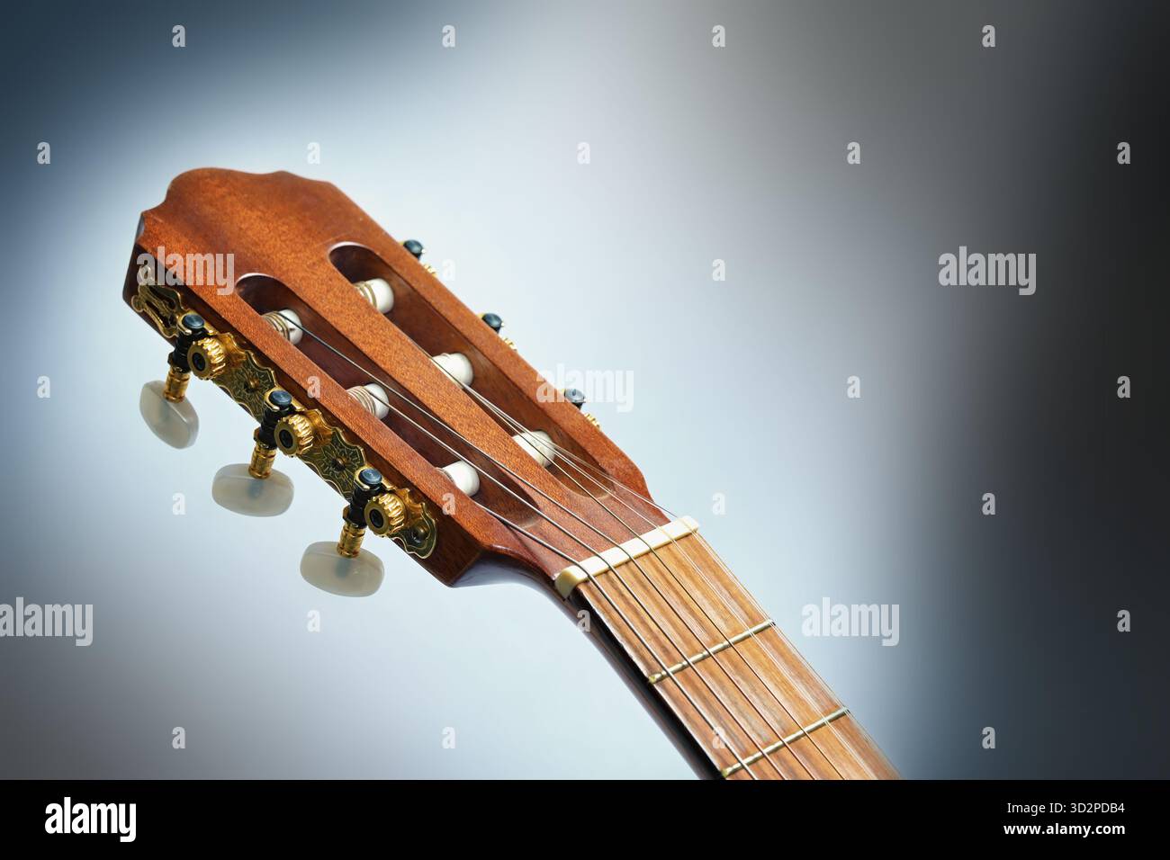 Klassische Gitarrenkopfstöcke oder Kopfhörern mit Stimmtasten, Streichern und Nuss, Teil des akustischen Musikinstruments, grauer Hintergrund, Kopierraum, selektiert Stockfoto