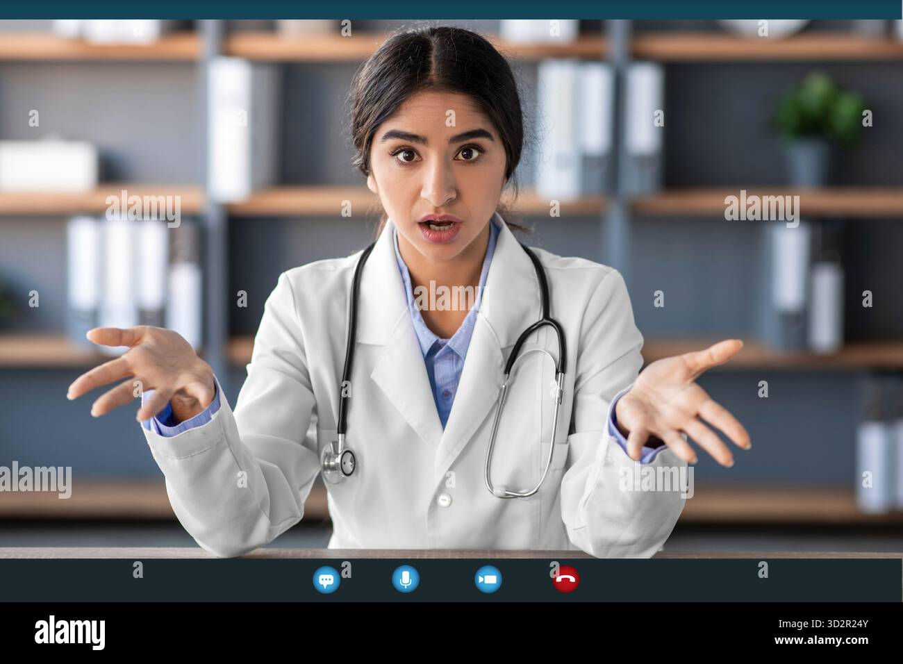 Junge Ärztin in Uniform drückt Begeisterung während der Remote Therapy Session aus Stockfoto