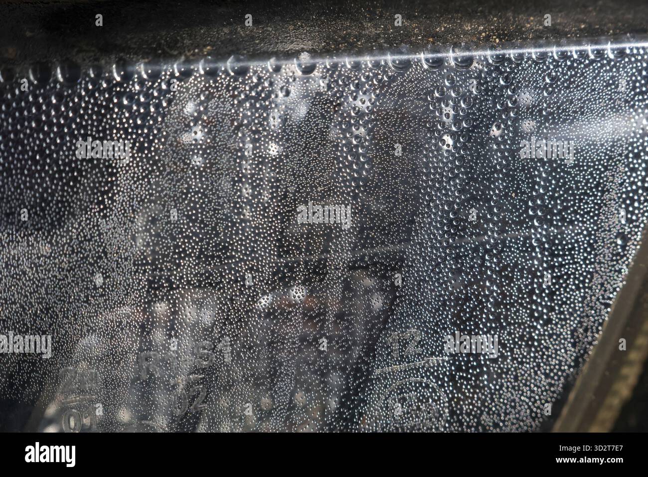 Moody abstrakter Hintergrund mit Wassertropfen und Kondensation auf nassem Glasfenster. Dampfende Textur erzeugt einen verschwommenen und atmosphärischen Effekt mit hoher Luftfeuchtigkeit Stockfoto