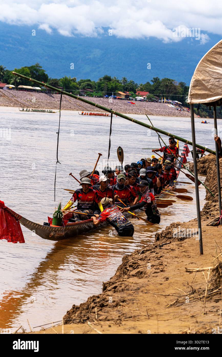 Traditionelles Bootsrennen-Team am Ufer, Attapeu, Laos – Boun Suang Heua Festival, Paddler in Kostümen, Gemeinschaftsgeist, Mekong-Kultur Stockfoto