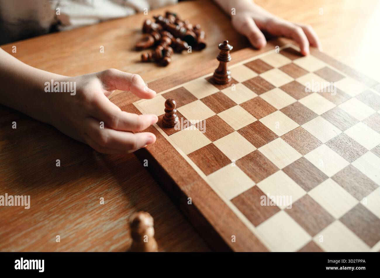 Kind spielt Schach mit Spielfiguren in strategischen Positionen. Stockfoto