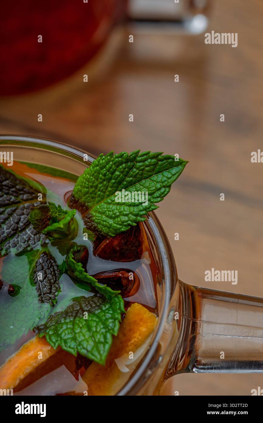 Herbsttee mit Gewürzen und Minze in einem transparenten Glas Stockfoto