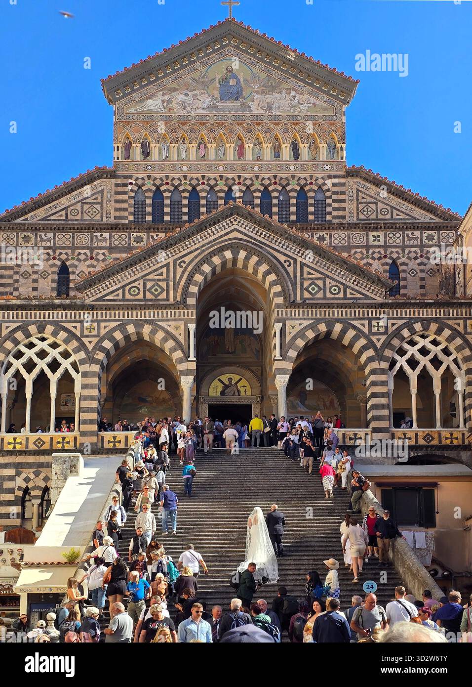 Kathedrale in Amalfi und eine Braut mit ihrem Vater, die viele Stufen klettern, die von den Touristen angefeuert wurden Stockfoto