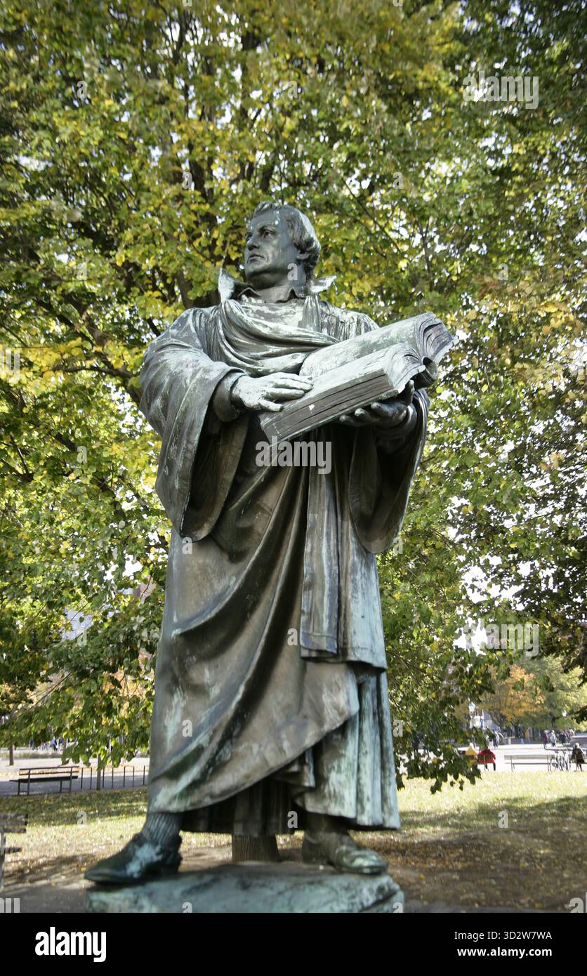 Martin Luther (1483-1546). Deutscher Theologe und Augustiner-Mönch. Statue von Martin Luther neben der Marienkirche in Berlin. Sie wurde 1895 von Paul Martin Otto (1846–1893) und Robert Toberentz (1849–1895) geschaffen. Luther ist mit einer offenen Bibel dargestellt, die eine ihrer Seiten berührt. Es war ursprünglich die zentrale Figur eines großen Denkmals, das 1945 zerstört wurde. Bronze. Stockfoto