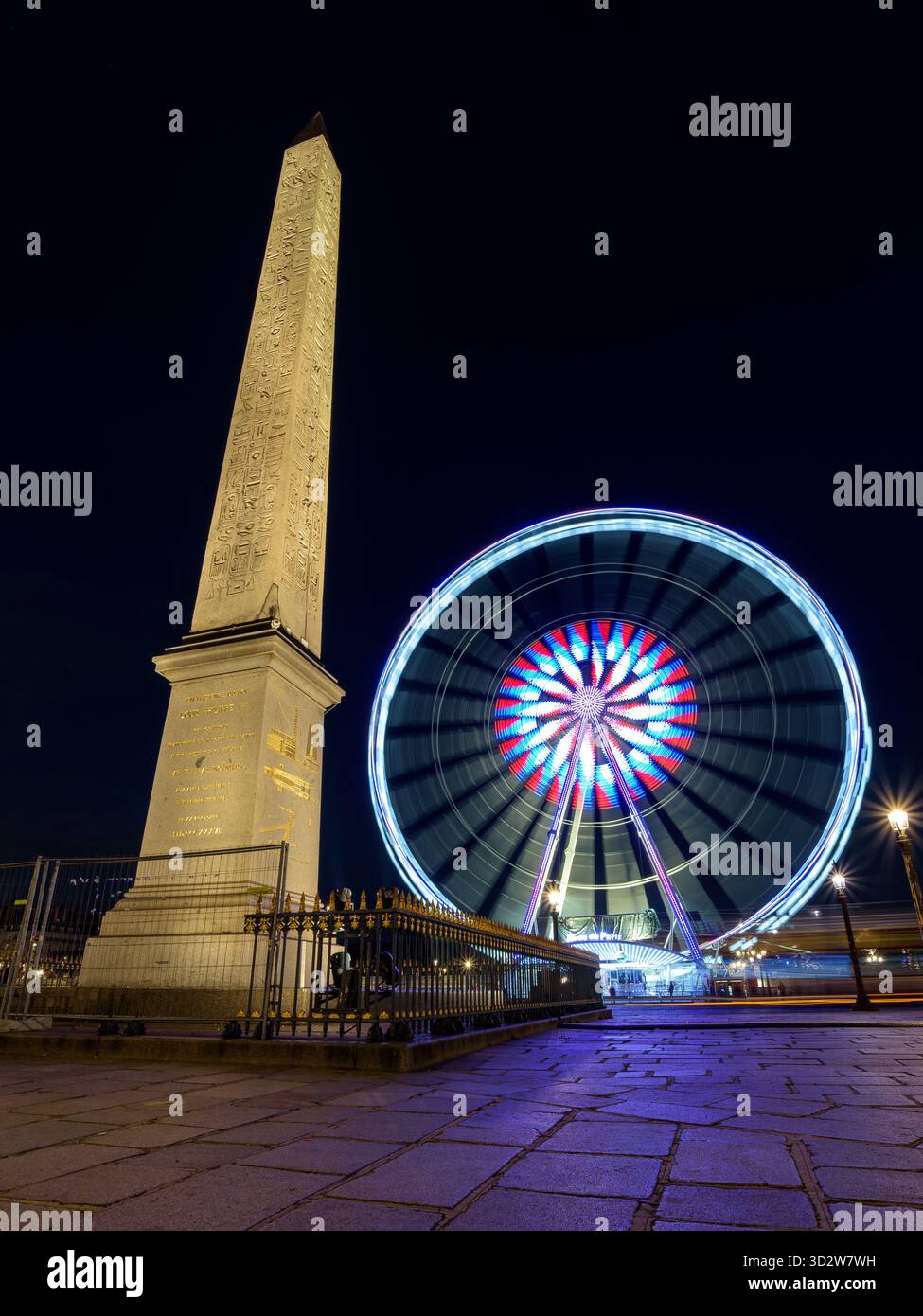 Der Luxor Obelisk und das Riesenrad bei Nacht, am Place de la Concorde im Zentrum von Paris. Stockfoto
