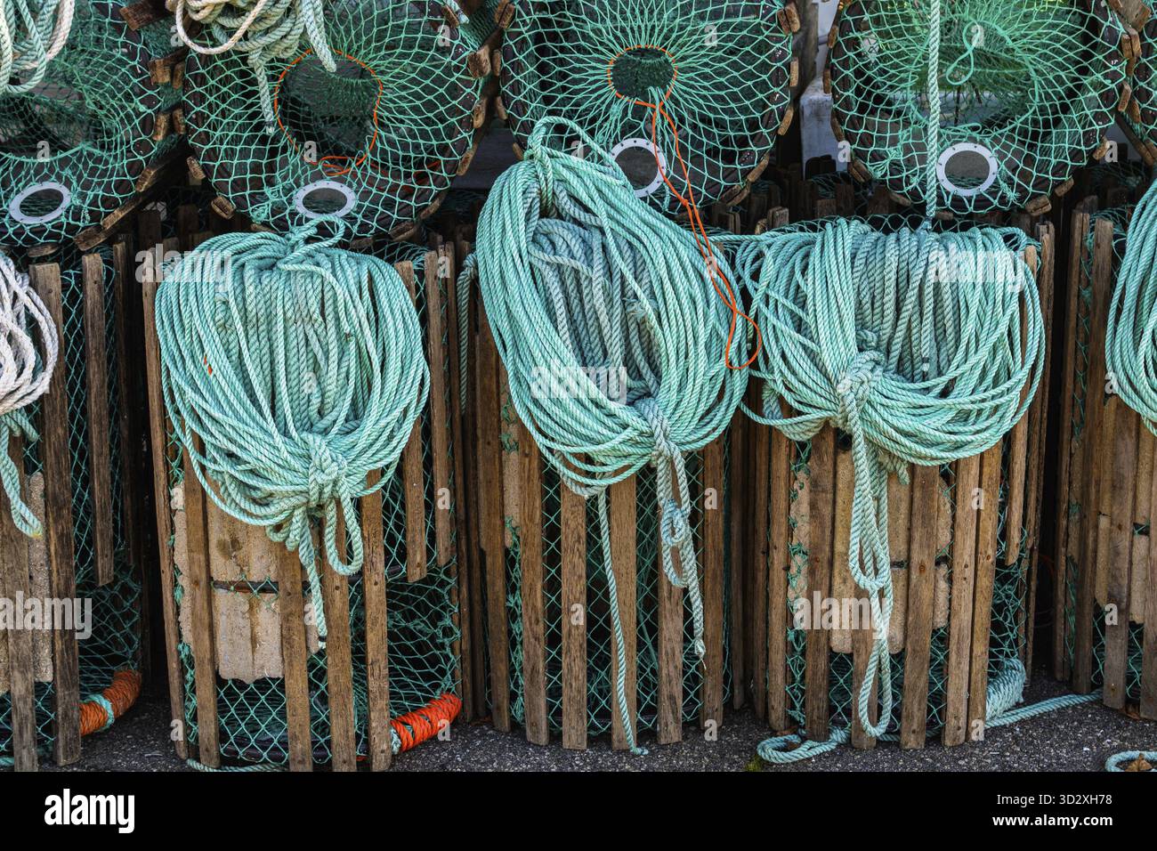 Hummerfallen stehen auf einem Pier, die zum Fischen mit Seilen und Bojen in einem norwegischen Fischerdorf vorbereitet sind Stockfoto
