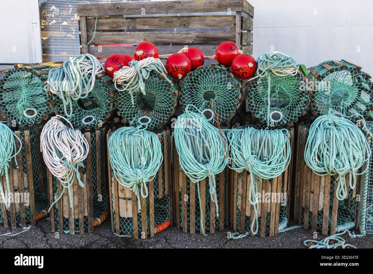 Hummerfallen stehen auf einem Pier, die zum Fischen mit Seilen und Bojen in einem norwegischen Fischerdorf vorbereitet sind Stockfoto