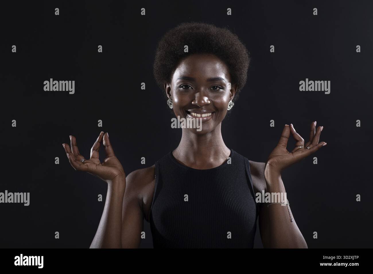 Studio-Porträt eines afroamerikanischen weiblichen Models mit Zen-Yoga-Mudra oder OK-Zeichen-Geste. Frau meditiert auf schwarzem Hintergrund Stockfoto