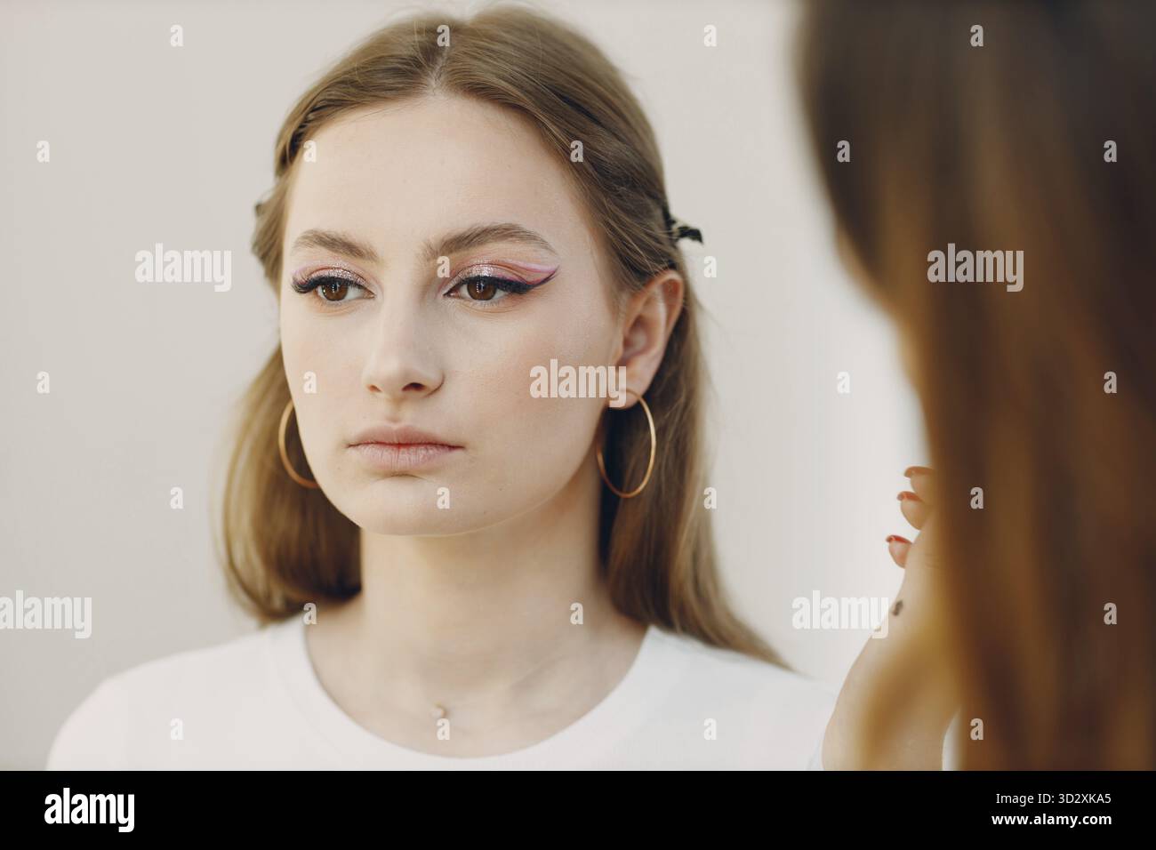 Schöne junge Frau, die Make-up-Schönheitsbürste aufträgt Stockfoto