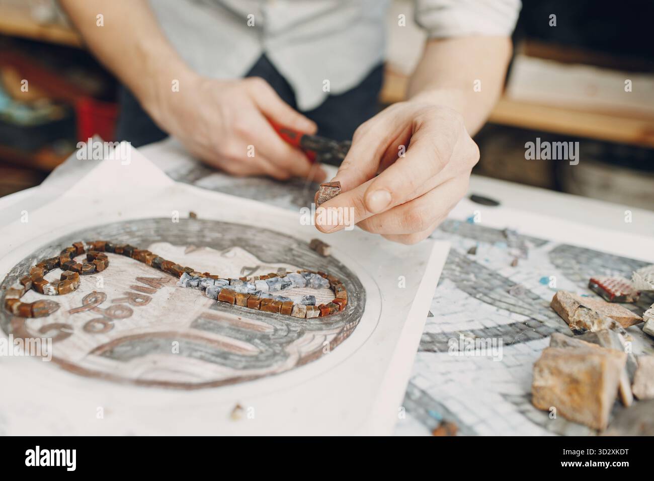 Werkstoffskizze und Werkzeuge zur Herstellung von farbigen Smalt-Glasmosaiken. Master Class, die Mosaikfrau antikes griechisches Porträt macht Stockfoto