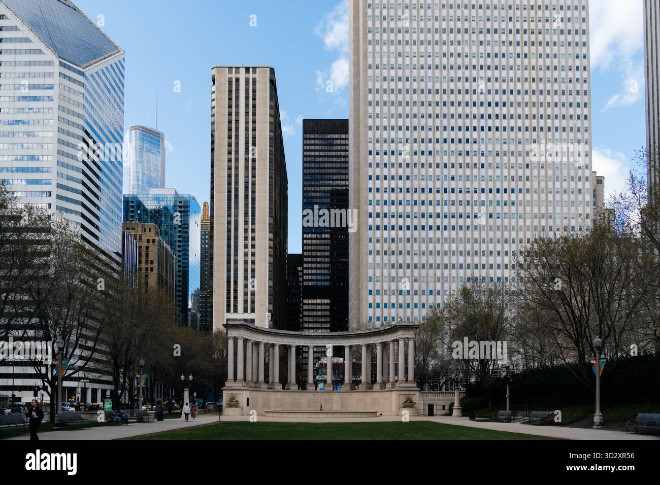 Chicago, USA - 15. April 2025: Blick auf Chicago mit dem Wrigley Square Peristyle Monument, umgeben von modernen Wolkenkratzern und üppig grünem Park Stockfoto
