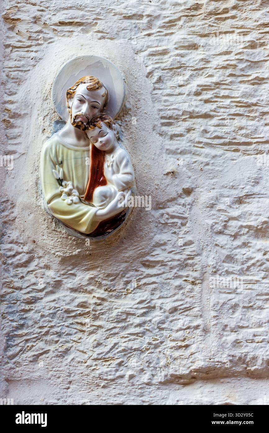 Religiöse Wandskulptur Des Heiligen Vaters Und Des Kindes Auf Weißem Steinmauerdekor Stockfoto