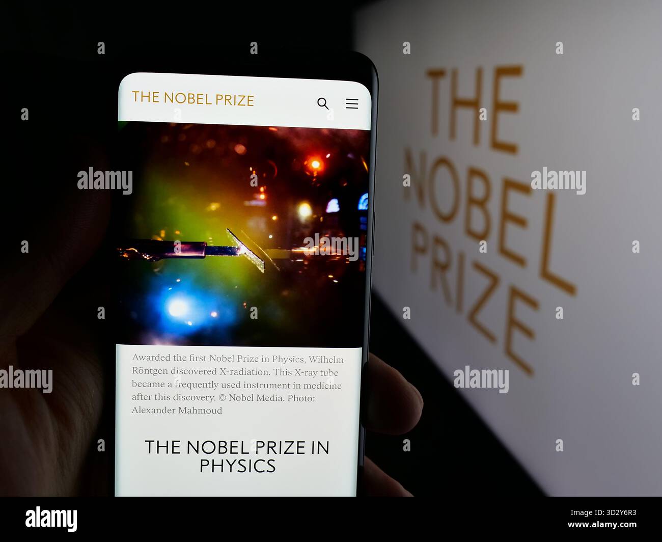 Stuttgart, Deutschland - 10-30-2025: Person, die ein Mobiltelefon hält, mit der Website der Nobelpreise auf dem Bildschirm vor dem Logo. Stockfoto
