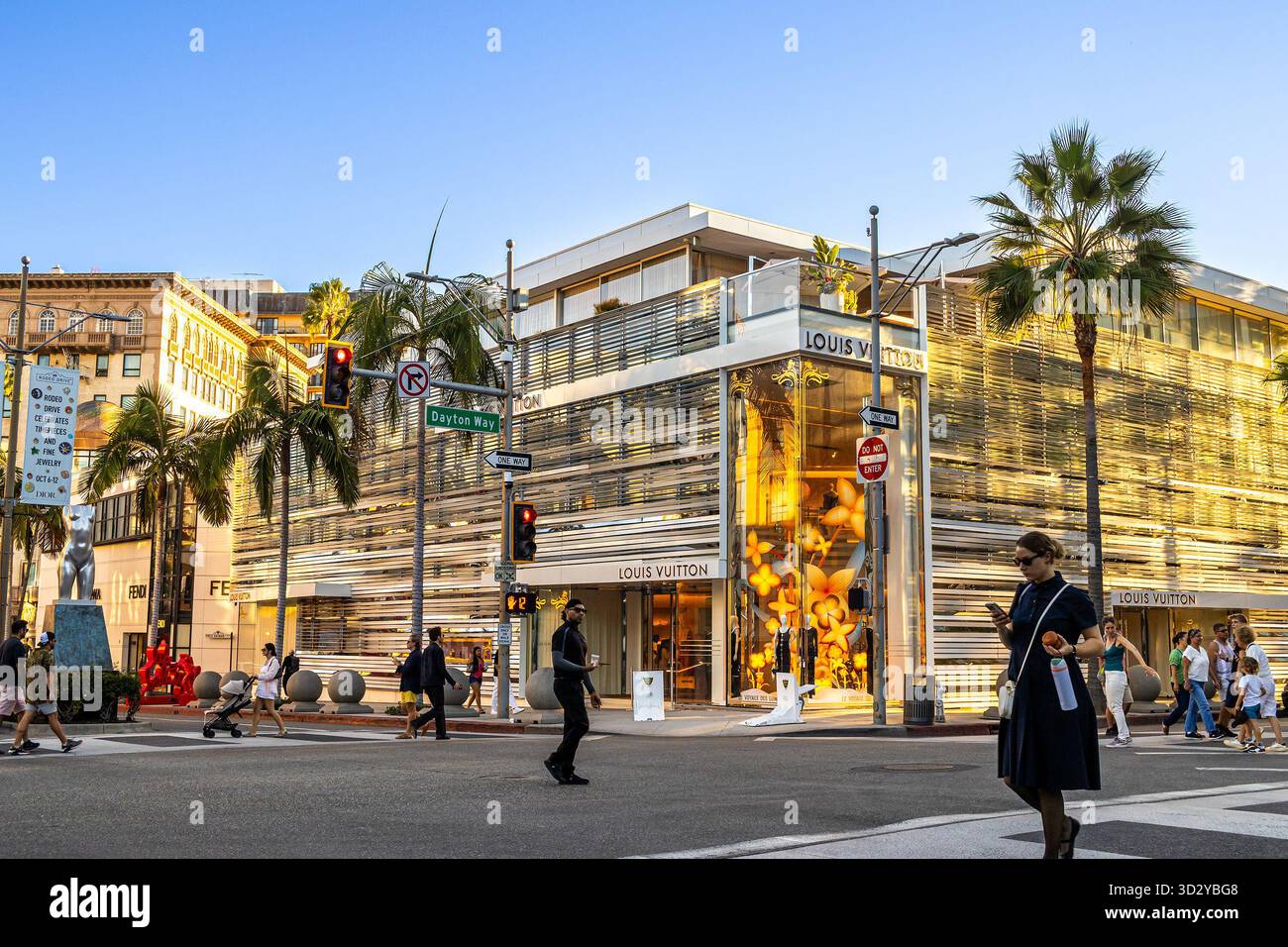 Außenansicht des Louis Vuitton Ladens am Rodeo Drive in Beverly Hills, Los Angeles, Kalifornien, mit Luxuskäufern unter Palmen Stockfoto