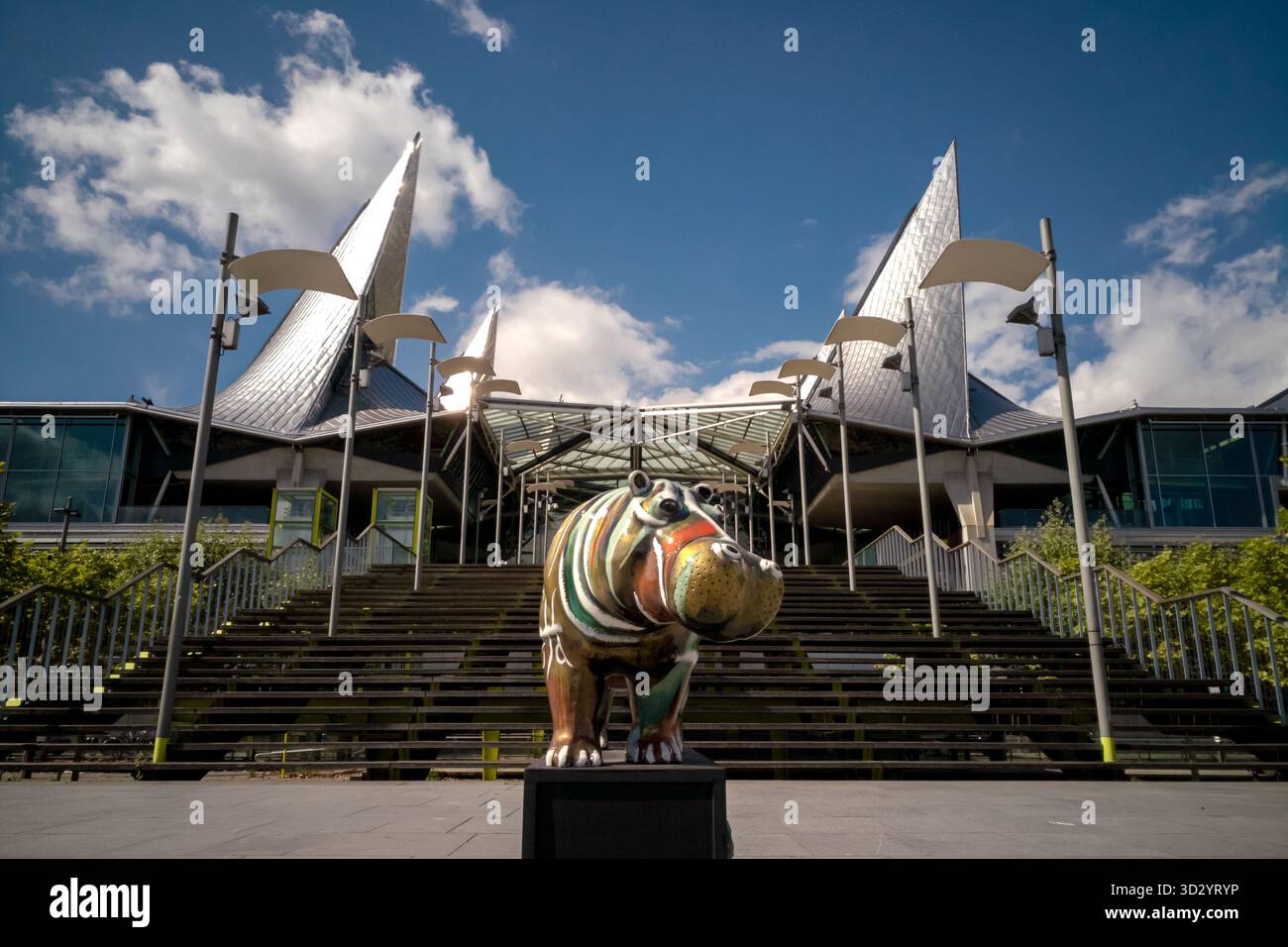 Antwerpen, Belgien - 23. August 2018 - farbenfrohe Nilpferdskulptur vor einem modernen Gebäude mit segelähnlicher Architektur unter blauem Himmel. Stockfoto