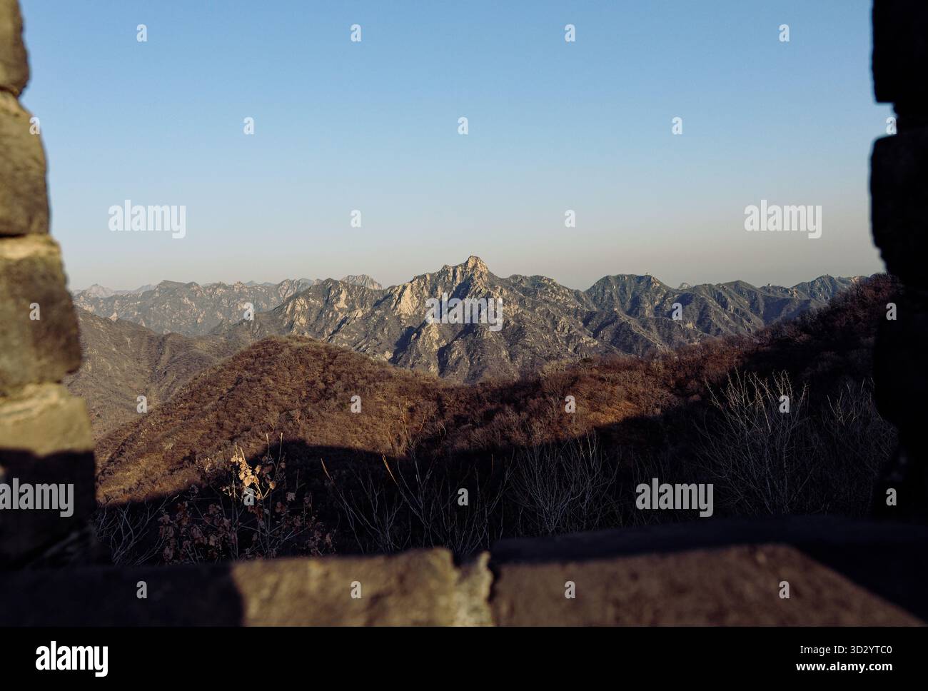 Zerklüftete Berggipfel, eingerahmt von den Steinmauern der Chinesischen Mauer Stockfoto