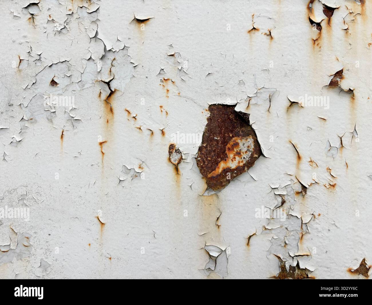 Rote Flecken abblätternder weißer Farbe auf rostigem Metall. Alterspuren auf Metall. Abstrakter Hintergrund Stockfoto