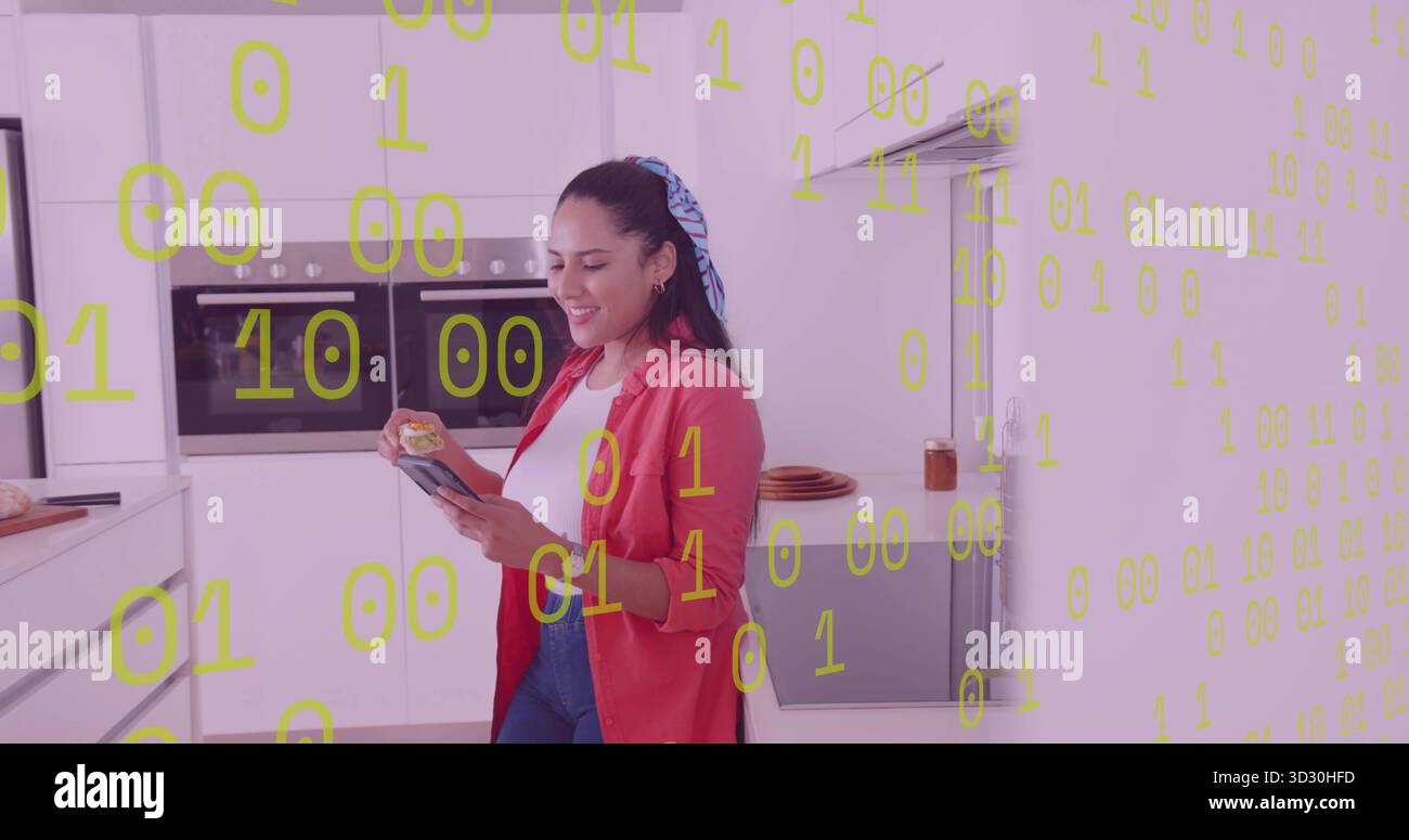 Smartphone und Snack halten, Frau, die in der Küche steht, mit schwimmendem Binärcode-Overlay Stockfoto