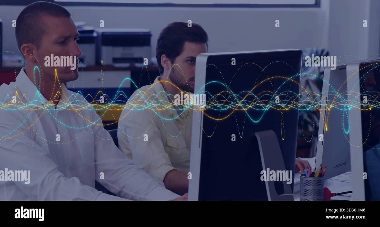 Vier Kollegen mit Fokus auf Desktop-Computer an modernen Bürotischen, mit Wellenform-Overlay Stockfoto