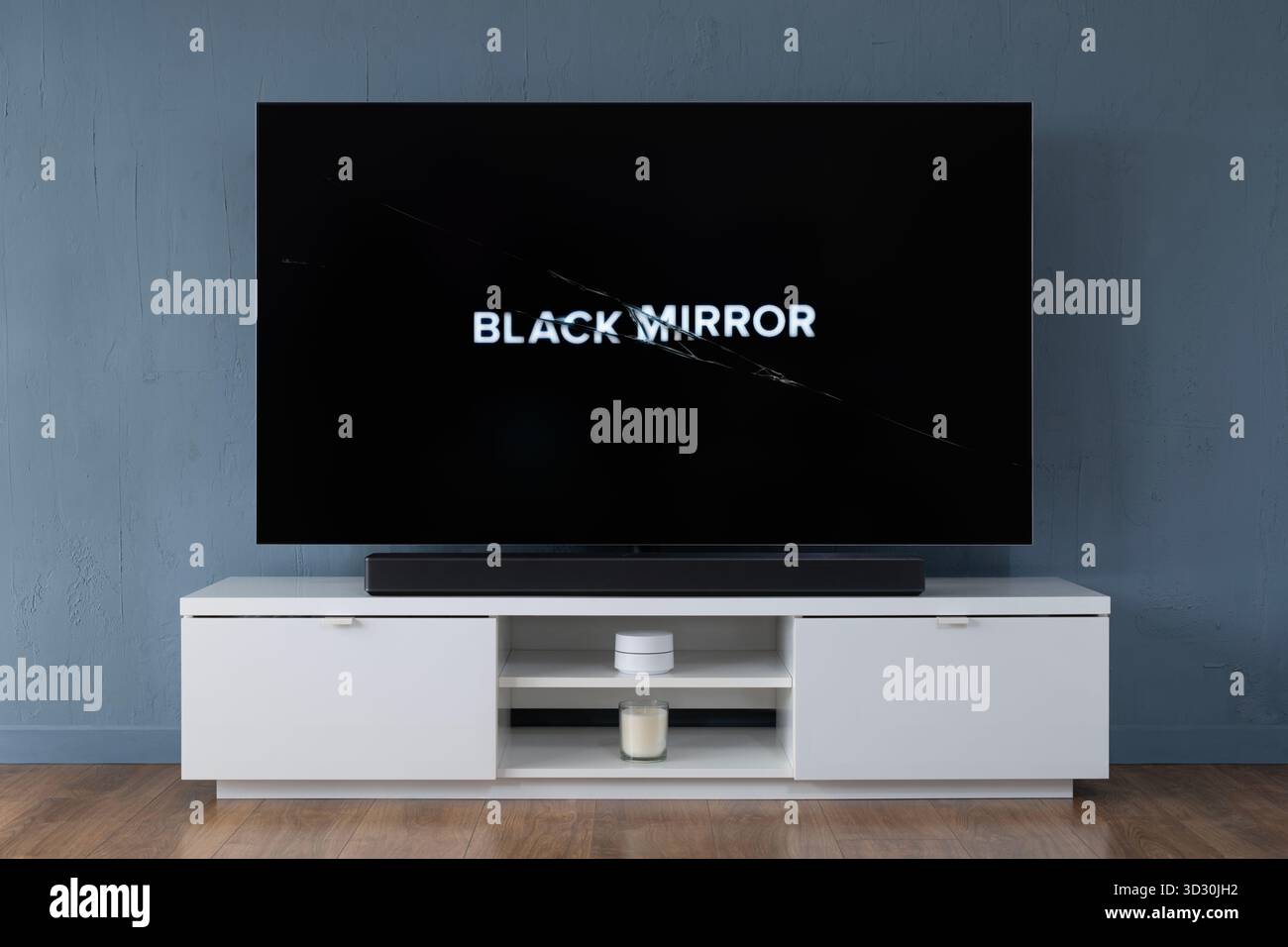 Ein Breitbild-OLED-Fernseher, der die Intro-Szene zur TV-Serie Black Mirror in einem modernen Wohnzimmer zeigt. Stockfoto