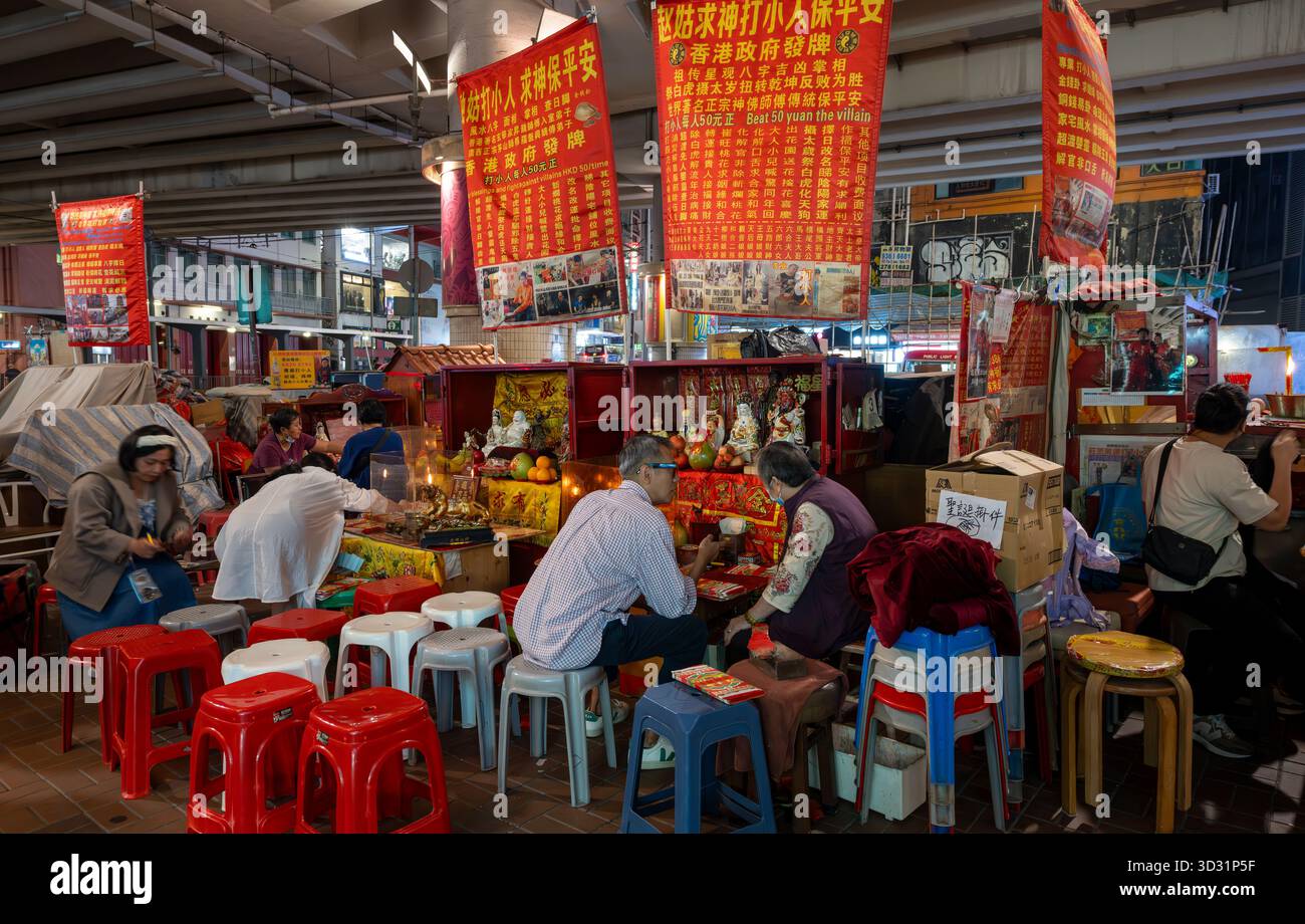 Stände von Bösewichten, die Kunst des „Bösewichtes schlagen“, ein altes Ritual, das in Hongkong praktiziert wird, um Unglück loszuwerden, Hongkong, China. Stockfoto
