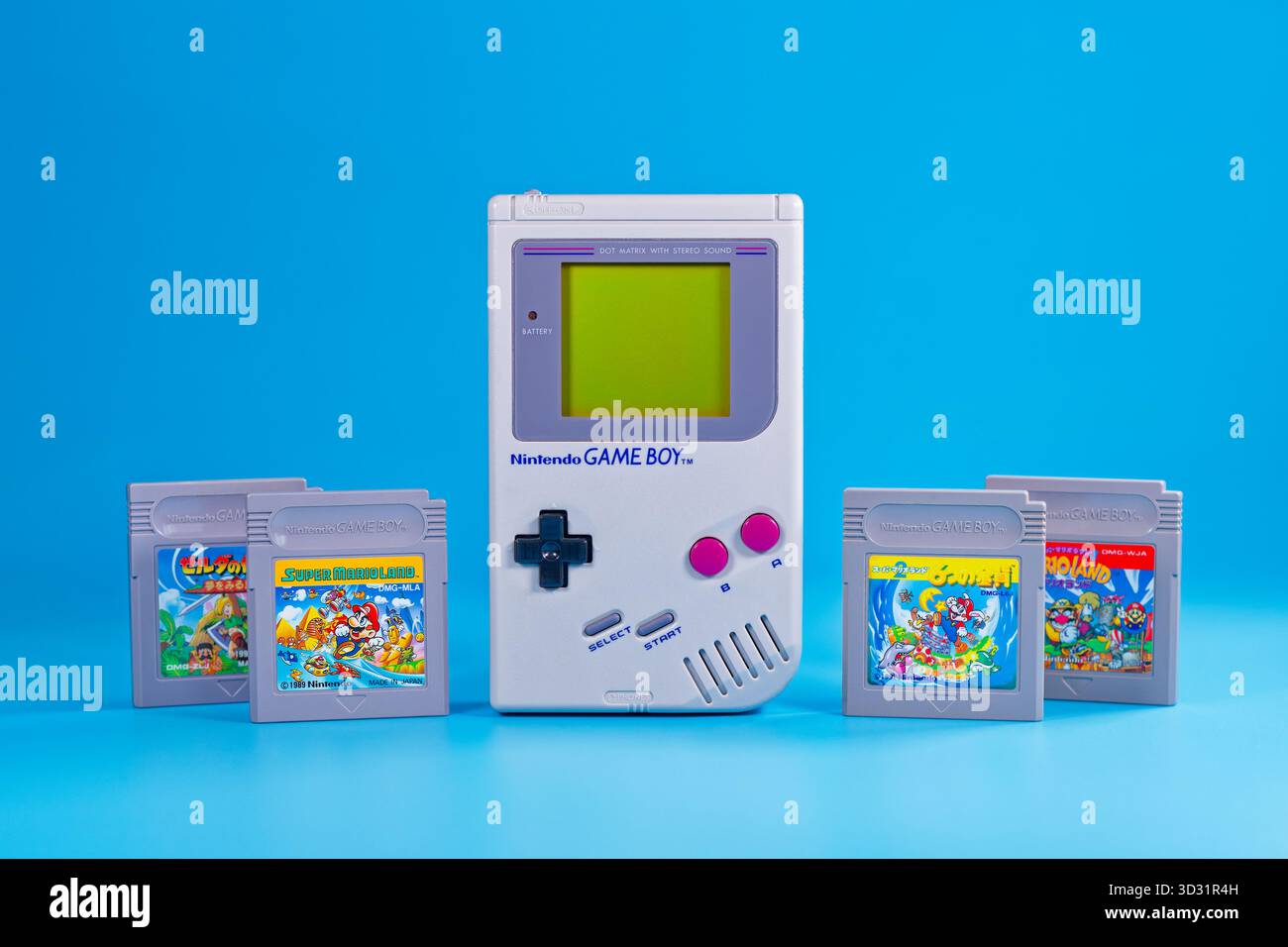 Fukuoka, Japan - 4. november 2025 : nintendo Game Boy mit verschiedenen Hit-Spielkassetten isoliert auf blauem Hintergrund Stockfoto