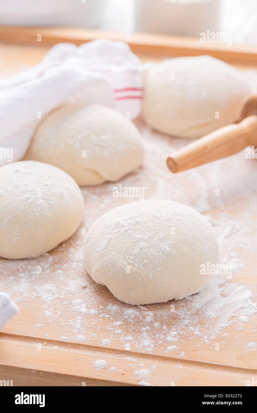 Roher Brotteig auf hölzernem Küchentisch, Brot oder Pizza backen Stockfoto