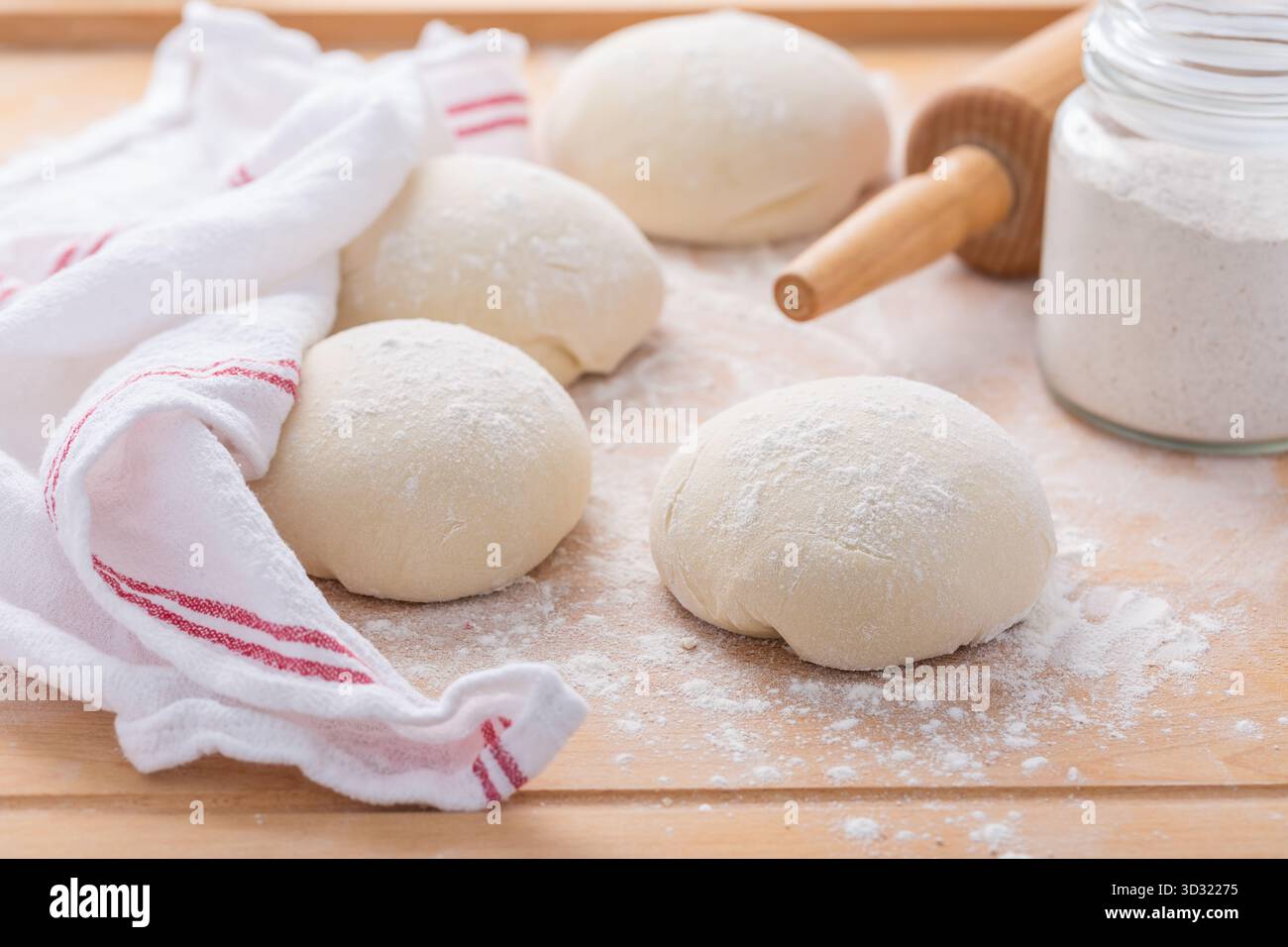 Roher Brotteig auf hölzernem Küchentisch, Brot oder Pizza backen Stockfoto