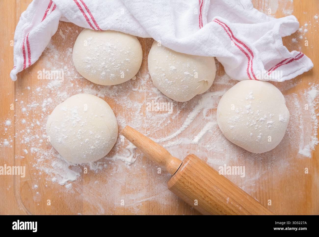Roher Brotteig auf hölzernem Küchentisch, Brot oder Pizza backen Stockfoto