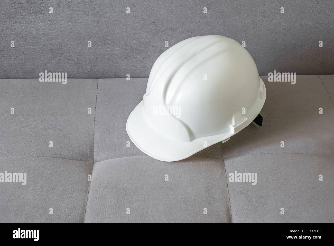 Weißer Bauhelm auf der Couch Stockfoto