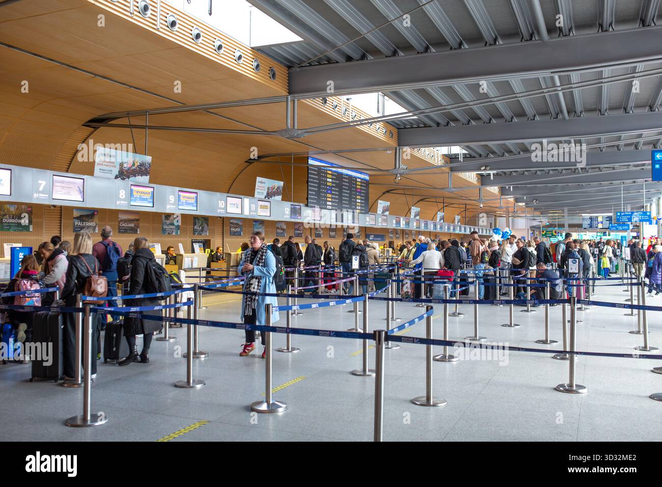 Posen, Polen - Oktober 30 2025: Personen stehen an den Check-in-Schaltern am Flughafen Posen Lawica an. Stockfoto