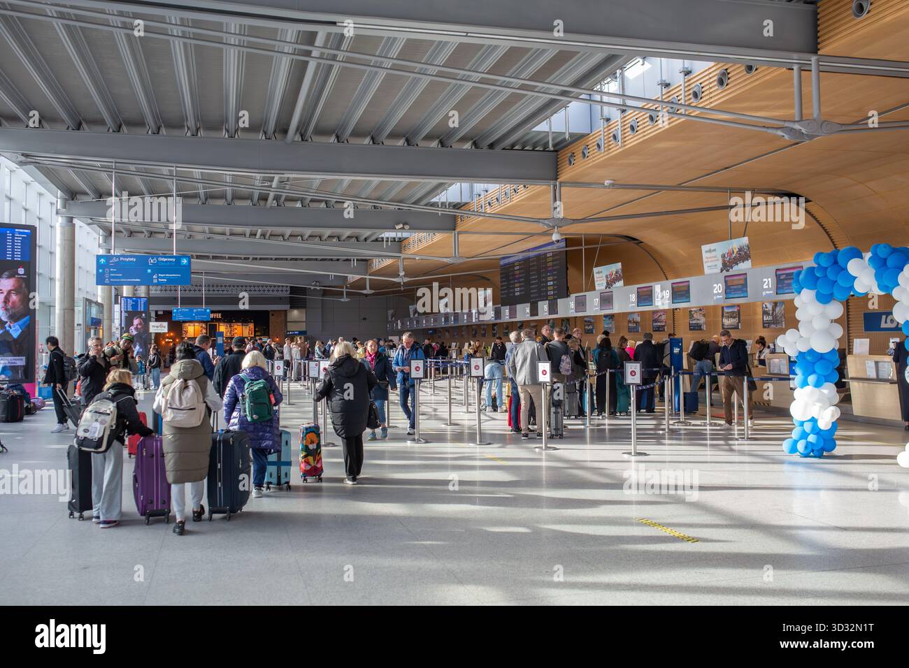 Posen, Polen - Oktober 30 2025: Personen stehen an den Check-in-Schaltern am Flughafen Posen Lawica an. Stockfoto