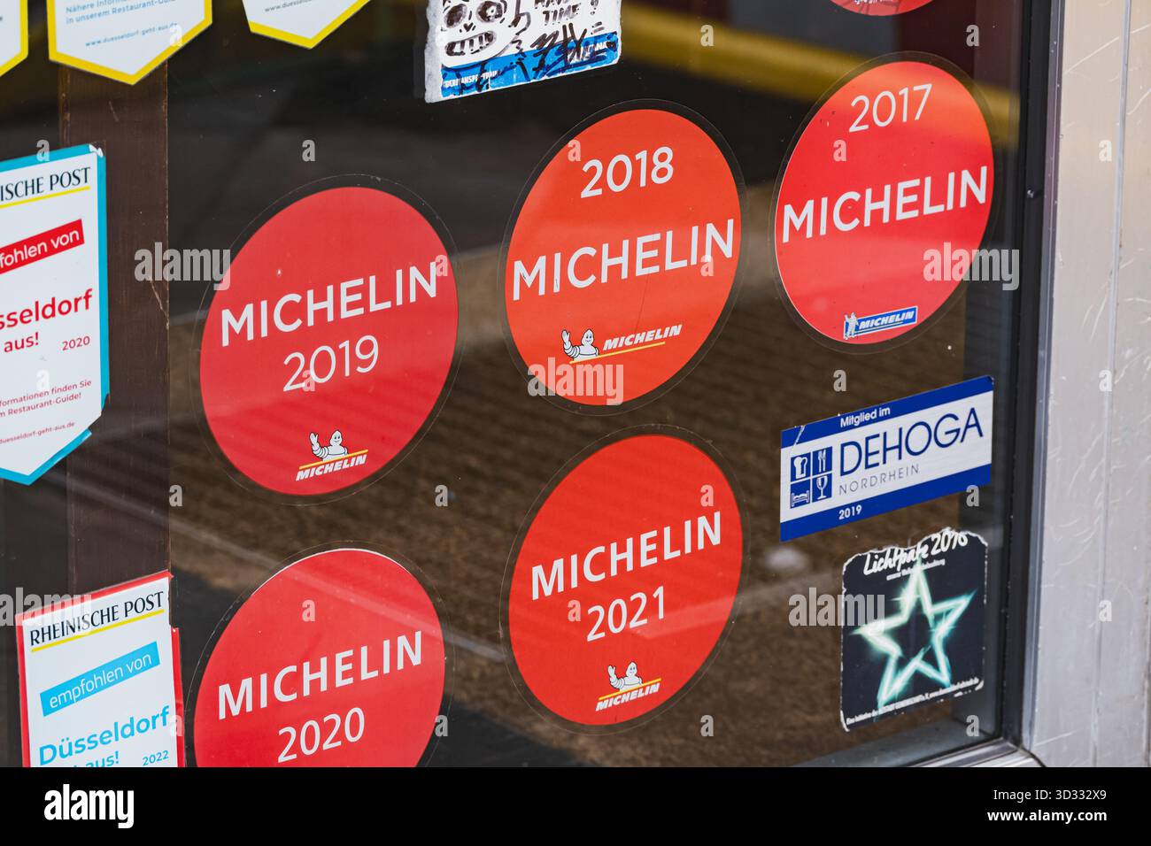 Mehrere Aufkleber mit dem Michelin-Restaurant auf einem Glasfenster am Eingang des Restaurants Stockfoto