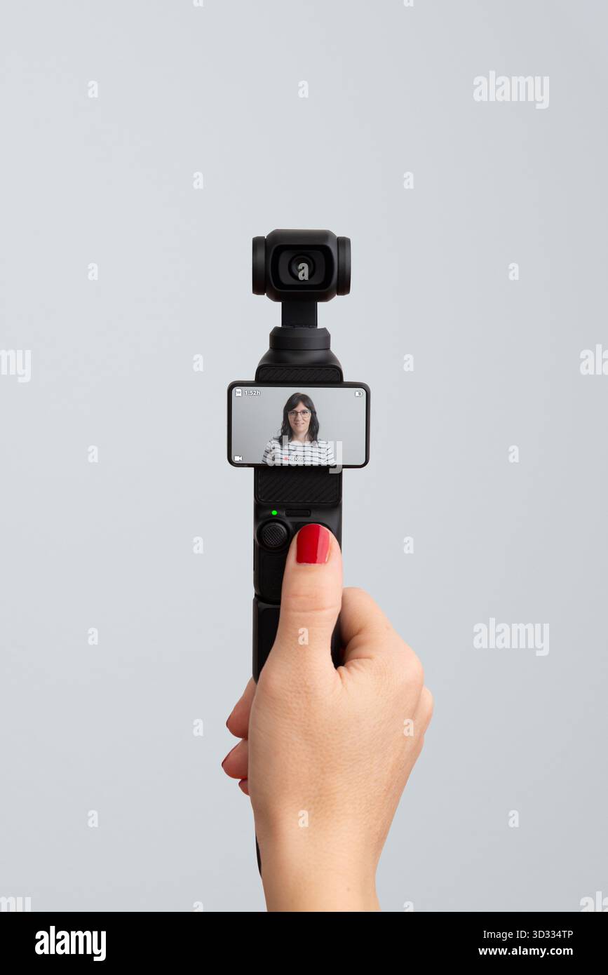 Kompakte Handkamera, die Frauen in Innenräumen aufnimmt, Konzept für modernes Vlogging, digitales Storytelling, Kreativität und Inhaltserstellung Stockfoto