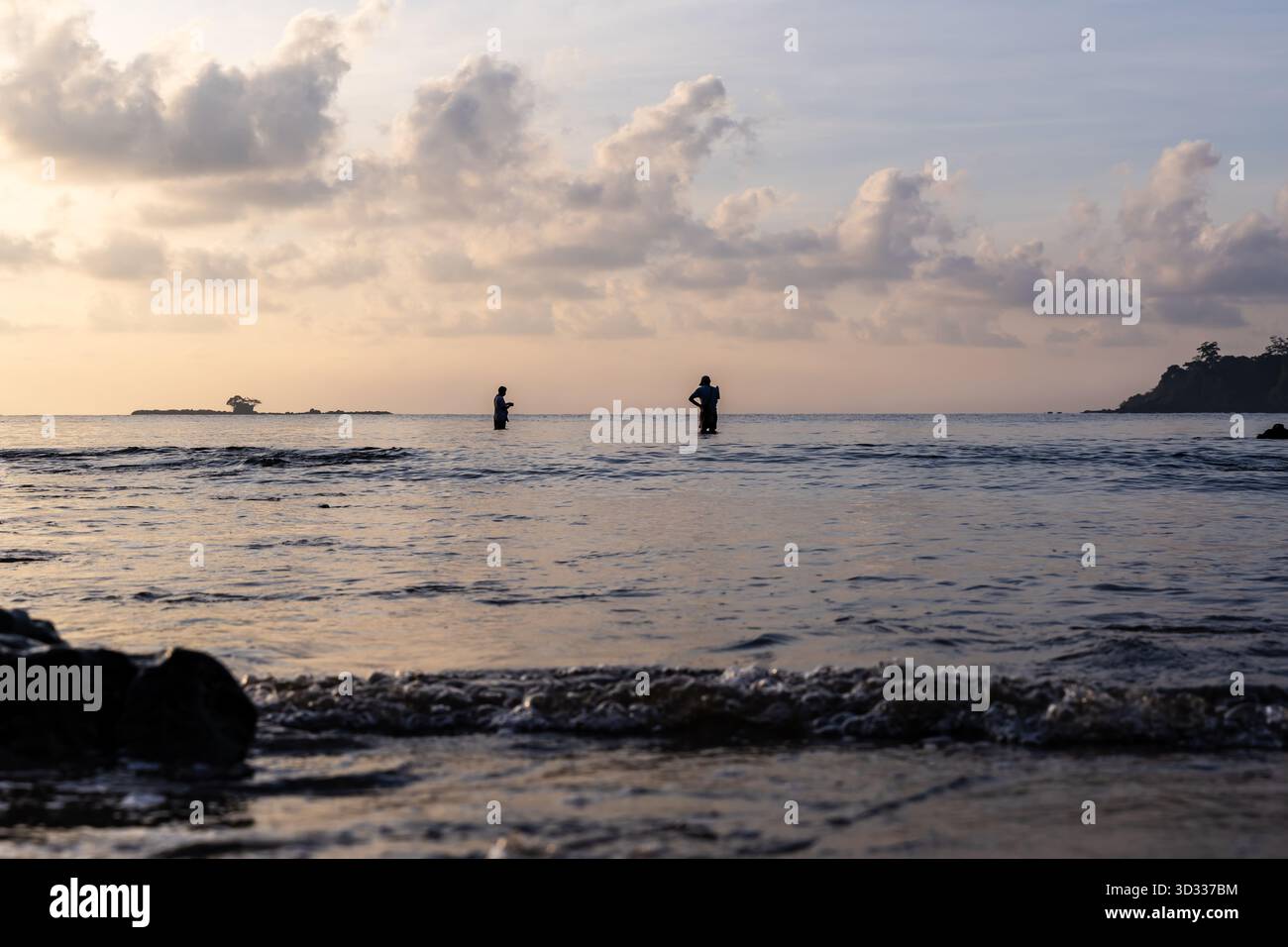Ein ruhiger Ozeanhorizont mit Fischern bei goldenem Sonnenuntergang wird am Corbyn’s Cove Beach, Port blair in Andaman und Nicobar Island, Indien, aufgenommen. Stockfoto