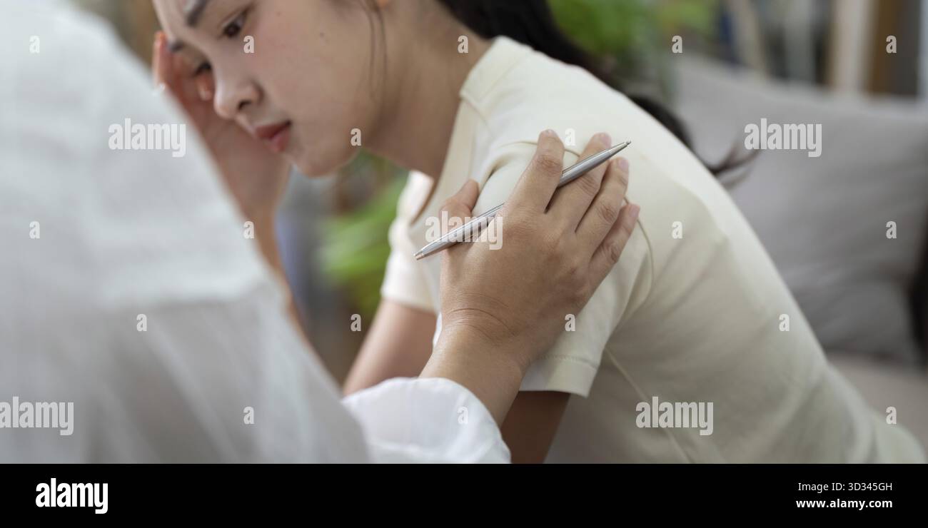 Eine junge Frau teilt ihre Gedanken, während eine Psychologin Notizen macht und die Bedeutung emotionaler Belastbarkeit in der Therapie unterstreicht Stockfoto