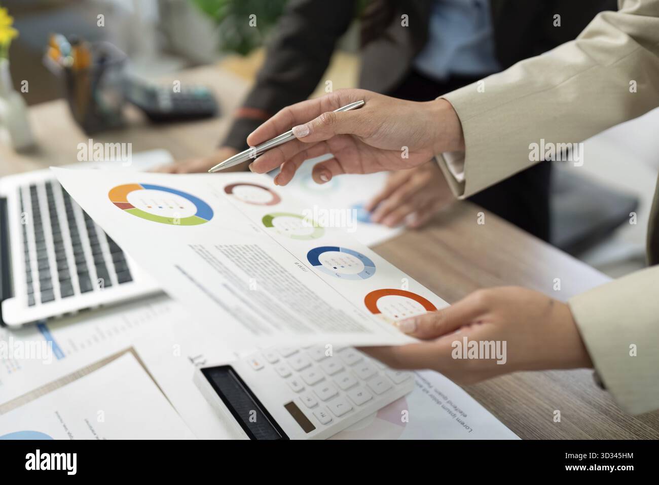 Zwei Geschäftsleute prüfen visuelle Datenberichte und diskutieren Erkenntnisse in einer gemeinsamen Büroumgebung Stockfoto