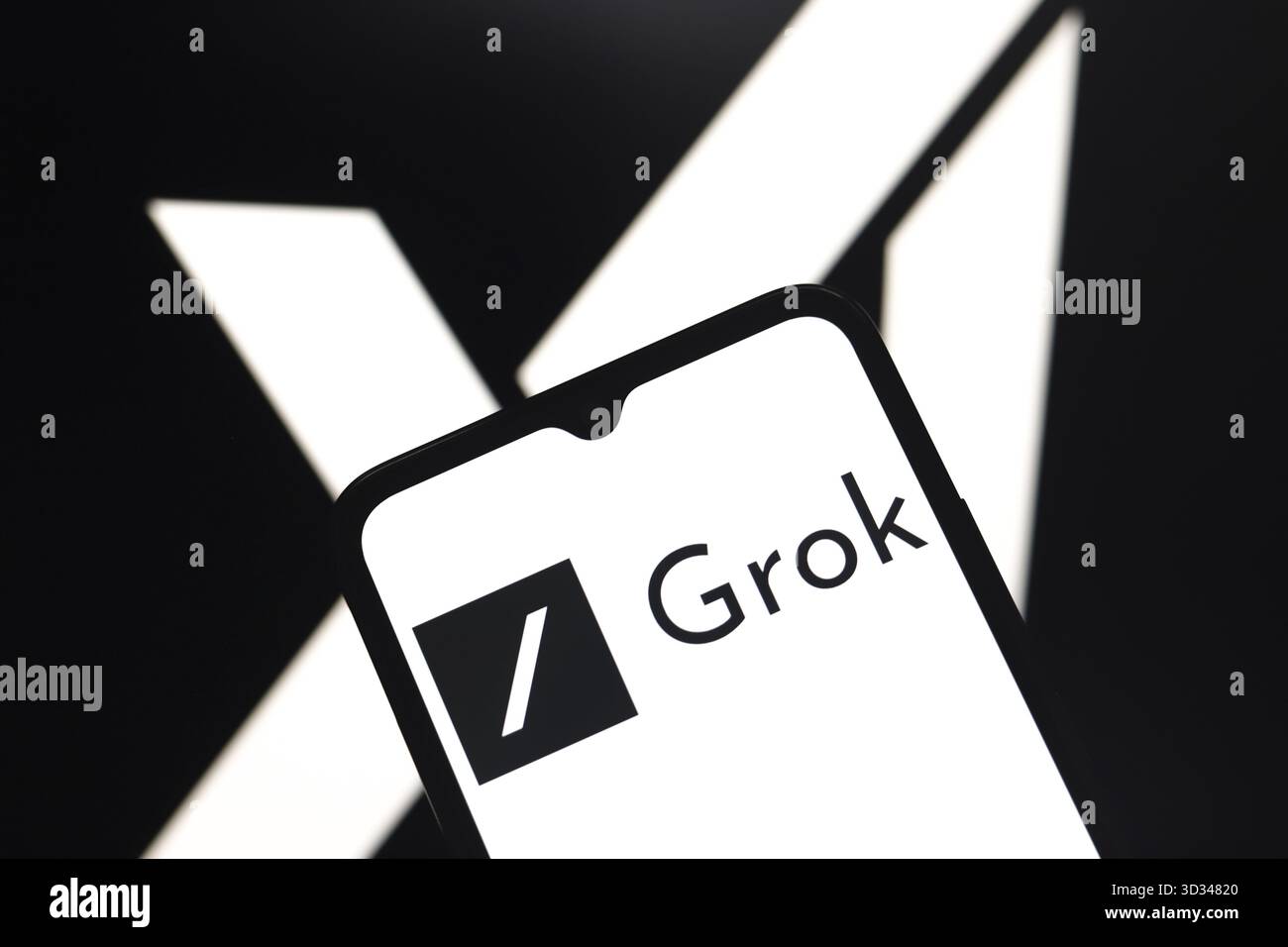 Das Grok-Logo wird auf dem Bildschirm eines Smartphones und im Hintergrund angezeigt, das XAI-Logo auf dem Computerbildschirm in Reno, USA, am Novemb Stockfoto