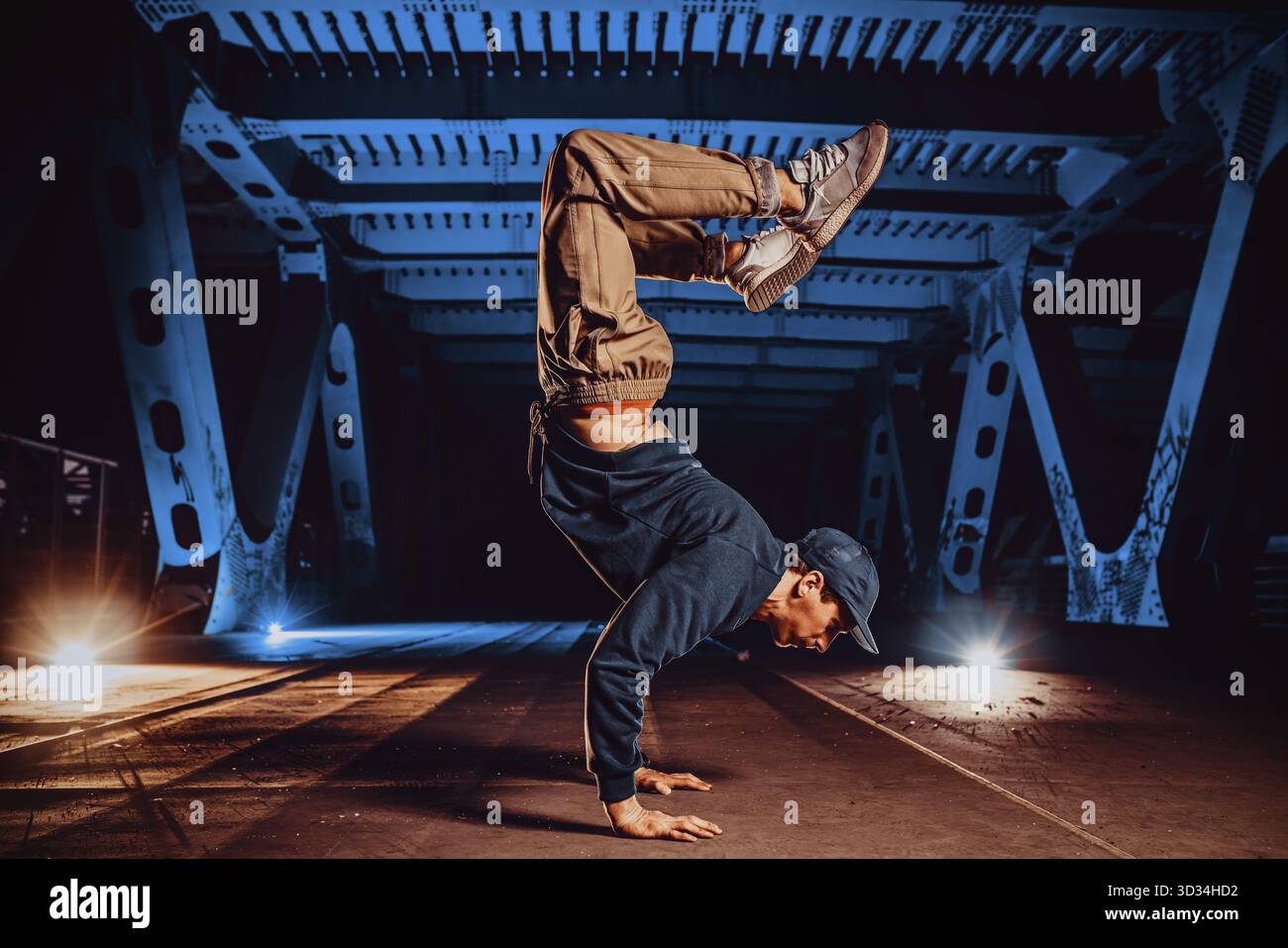 Ein junger, cooler Mann, der nachts auf einer Stadtbrücke posiert Stockfoto