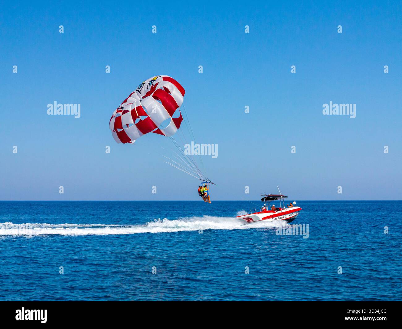 Touristen, die von einem Motorboot aus im Mittelmeer vor der Küste von Protaras im Osten Zyperns parasailing oder Parasailing. Stockfoto