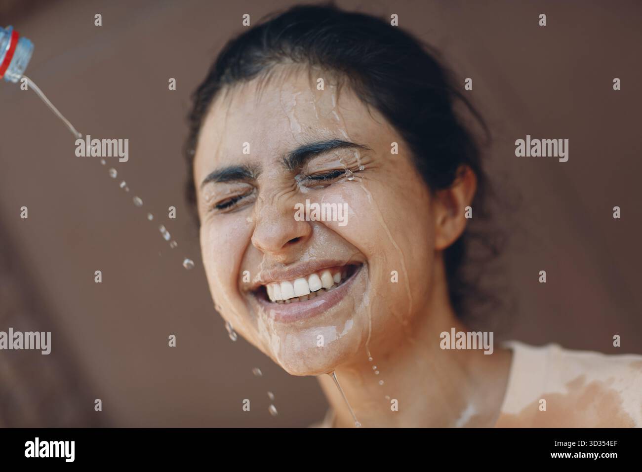 Gestresste Frau, die unter einem Hitzschlag und erfrischendem Ausgießen mit kaltem Wasser leidet. Wetter abnorme Wärme Konzept Stockfoto