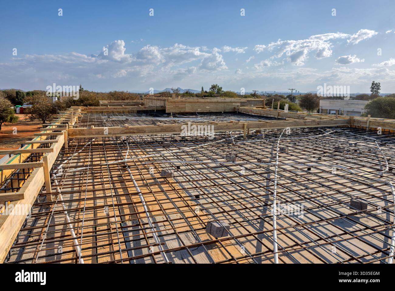 Baubodenplatte, vorbereitet für einen Betongieß, Gitter aus Stahlbewehrungsstahl, das ein Verstärkungsnetz bildet. Holzformen und -Spangen, Rohre für elektrische Bedingungen Stockfoto