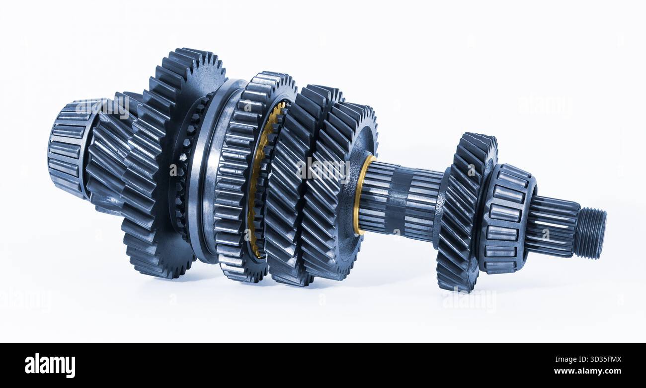 Interner Zahnradmechanismus im Schaltgetriebeteil auf weißem Hintergrund. Großaufnahme einer blau-metallischen Getriebewelle mit verschiedenen Zahnrädern aus Stahl. Stockfoto