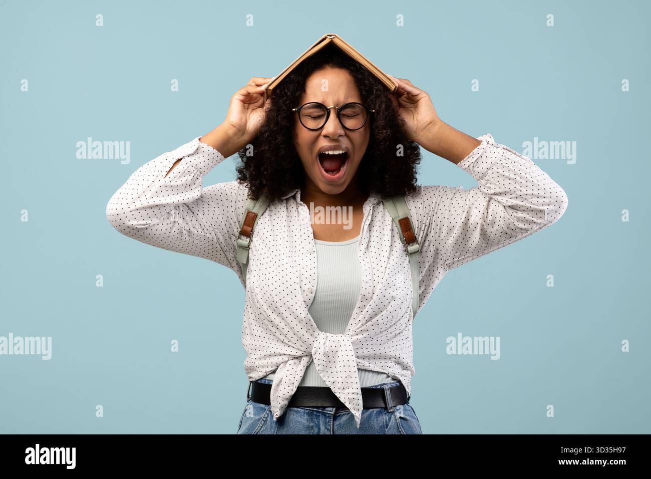 Junge Schwarze Frau drückt Frustration aus, während sie im Blue Studio studiert Stockfoto