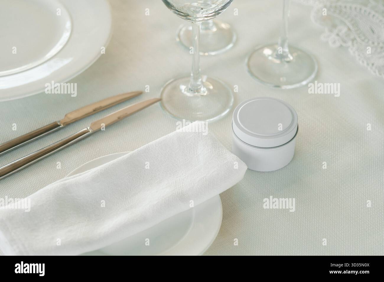 Ein wunderschön angeordneter Tisch mit poliertem Silberbesteck, glitzernden Gläsern und einer ordentlich gefalteten Serviette schafft eine einladende Atmosphäre für einen Stockfoto