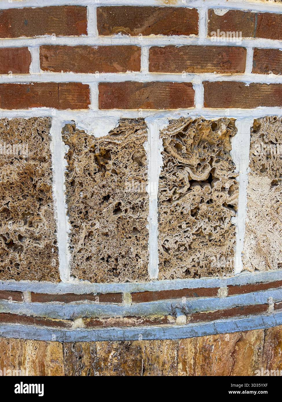 Nahaufnahme einer Ziegelmauer und einer porösen Steinmauer mit sichtbaren Mörtellinien, die rustikale Texturen und architektonische Details in natürlichen Braun- und Grautönen zeigt - Smartphone-aufgenommenes Stockfoto